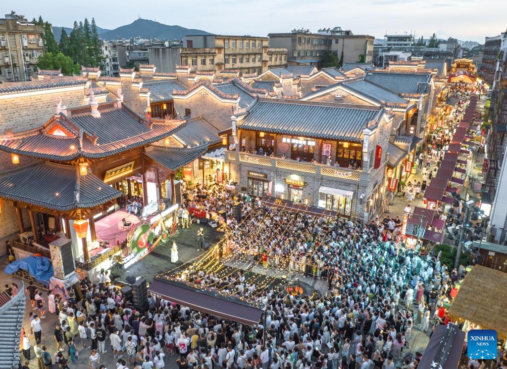 An aerial drone photo taken on July 25, 2025 shows tourists watching a nighttime performance in Xiangyang ancient town in Xiangyang City, central China's Hubei Province. With heat waves gripping many regions across the country, diverse cooling tourism events, such as water-related activities and night tours, have grown in popularity, invigorating the summer economy. (Photo: Xinhua)