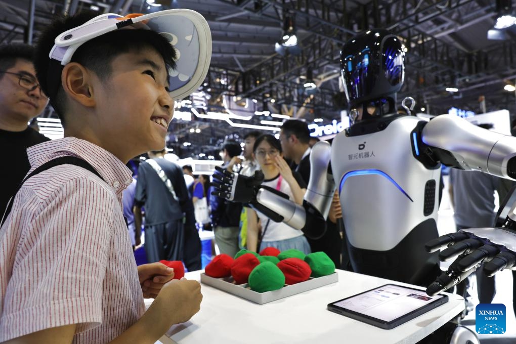 A child plays a game with a humanoid robot at the exhibition area of the 2025 World AI Conference and High-Level Meeting on Global AI Governance in east China's Shanghai, July 26, 2025. The event kicked off here on Saturday. More than 1,000 officials and representatives of industries, universities and research institutes from home and abroad attended the opening ceremony. (Photo: Xinhua)
