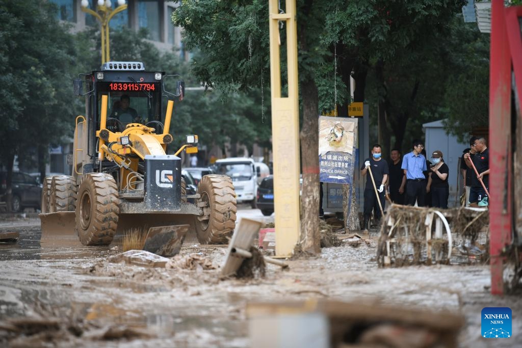 An engineering machine clears up silt on a street after flood in Wuqi County of Yan'an City in northwest China's Shaanxi Province, July 26, 2025. Heavy rainfall has affected Wuqi County since Thursday, resulting in severe flooding. Local authorities have activated Level-III emergency response for flood prevention and control, with dedicated resources for disaster relief and restoration. Most major streets in Wuqi have been cleared, water supply largely resumed, and no reports of casualties have been received as of Saturday, according to the county authority in charge of flood response. (Photo: Xinhua)