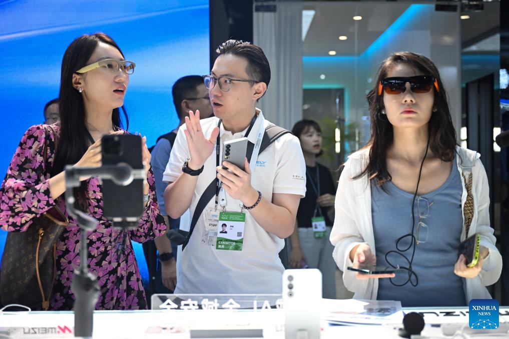 A staff member (C) introduces an AR glasses product to visitors at the exhibition area of the 2025 World AI Conference and High-Level Meeting on Global AI Governance in east China's Shanghai, July 26, 2025. The event kicked off here on Saturday. More than 1,000 officials and representatives of industries, universities and research institutes from home and abroad attended the opening ceremony. (Photo: Xinhua)
