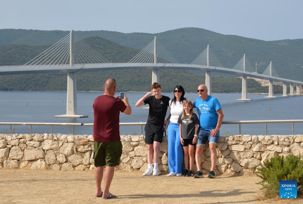 Visitors pose for photos with the Peljesac Bridge in Komarna, Croatia on July 26, 2025. (Photo: Xinhua)