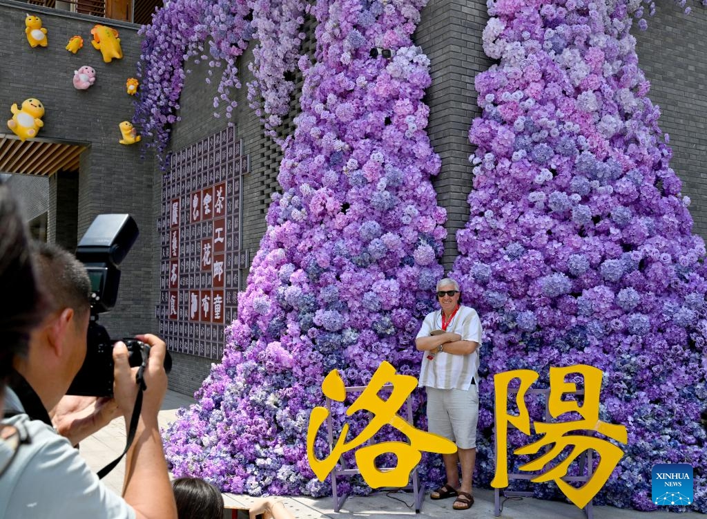 A participant of the Shanghai Cooperation Organization (SCO) Media and Think Tank Summit poses for photos at a street in Luoyang, central China's Henan Province, July 26, 2025. The SCO Media and Think Tank Summit is held in Zhengzhou from July 23 to 27. Participants are invited to visit various locations in Henan during the summit. (Photo: Xinhua)