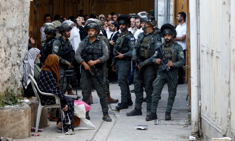 Members of the Israeli forces stand guard as Israeli settlers visit a community mostly inhabited by Palestinians in the West Bank city of Hebron, on July 26, 2025. (Photo: Xinhua)