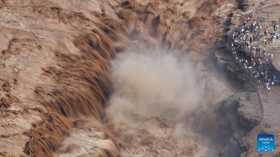 An aerial drone photo taken on July 27, 2025 shows people visiting the Hukou Waterfall on the Yellow River in Jixian County, north China's Shanxi Province. Hukou waterfall is witnessing an increasing water flow lately. (Photo: Xinhua)