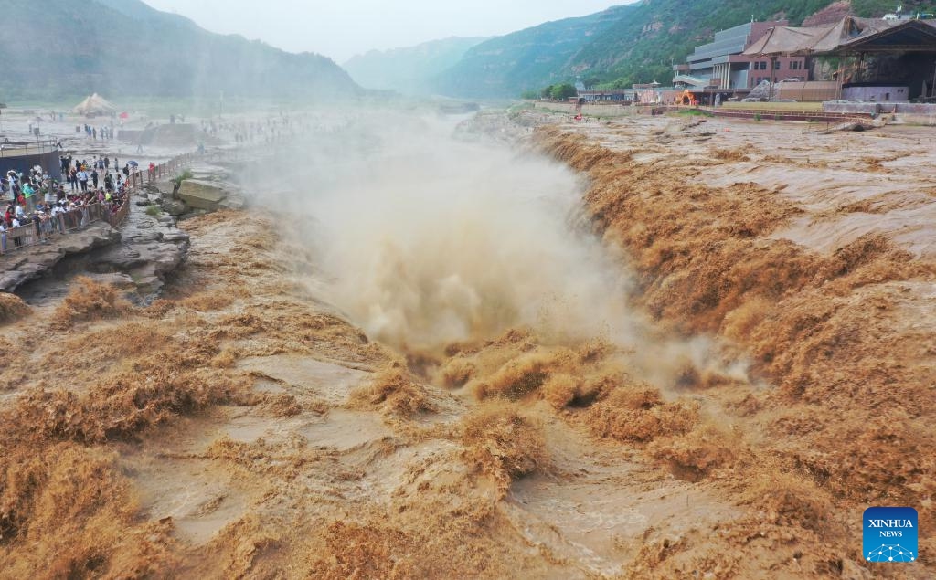 An aerial drone photo taken on July 27, 2025 shows people visiting the Hukou Waterfall on the Yellow River in Jixian County, north China's Shanxi Province. Hukou waterfall is witnessing an increasing water flow lately. (Photo: Xinhua)
