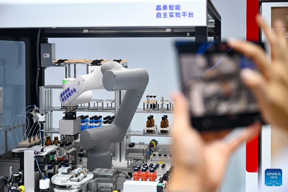 A visitor takes photos of a product at the booth of XtalPi during the 2025 World AI Conference in east China's Shanghai, July 27, 2025. The ongoing 2025 World AI Conference showcases the world's latest AI advancements while providing a platform for visitors to access AI products and technologies. (Photo: Xinhua)