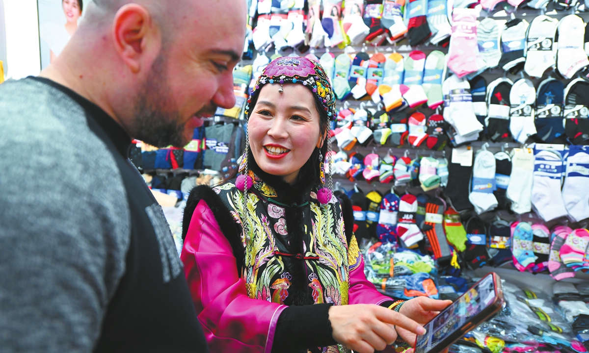 Fu Jiangyan (right), a merchant in Yiwu, East China's Zhejiang Province, introduces her products to a foreign customer with AI tools on February 25, 2025. Photo: VCG