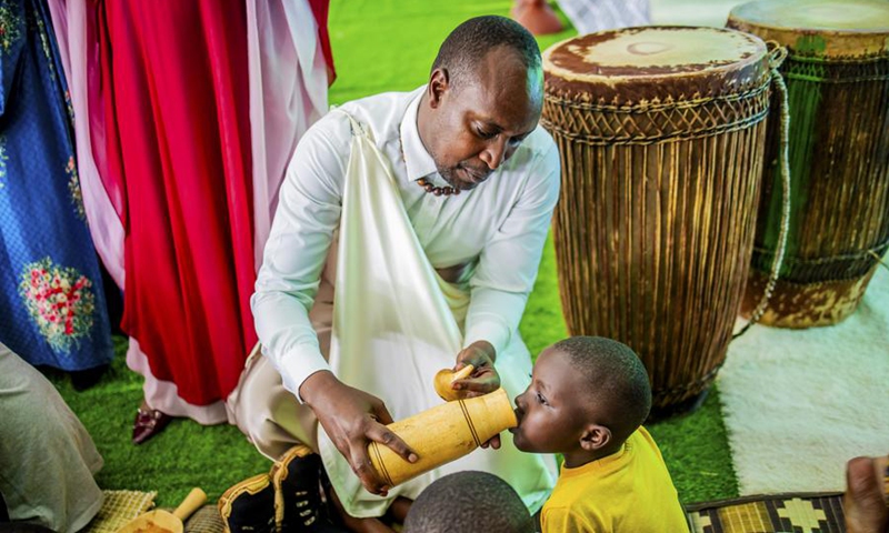 A guest serves milk to a child during a national harvest day celebration in Kicukiro District, Rwanda, Aug. 1, 2025. Photo: Xinhua