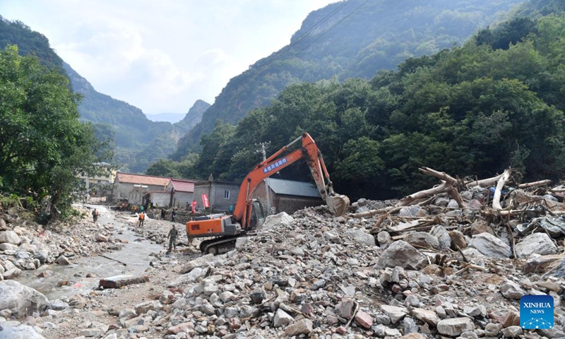 Staff members operate a digger to clean up rocks in Zhujiagou Village in Liudaohe Town, Xinglong County of north China's Hebei Province, Aug. 1, 2025. Affected by heavy rainfall, some roads and houses were damaged in several villages in Liudaohe Town. In recent days, local authorities have organized efforts to carry out relief operations to restore roads, power supply and communication facilities, along with environmental disinfection measures. Photo: Xinhua