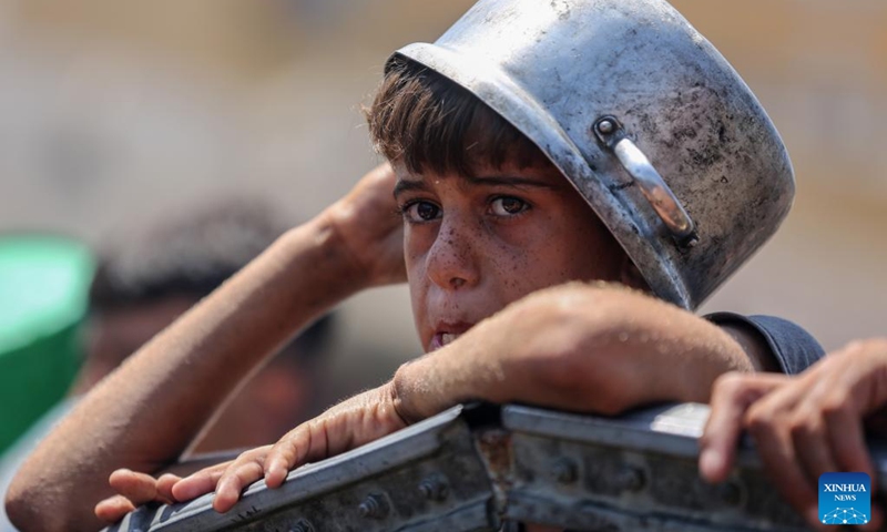 A Palestinian boy waits to receive free food from a food distribution center in Gaza City, on Aug. 2, 2025. Photo: Xinhua