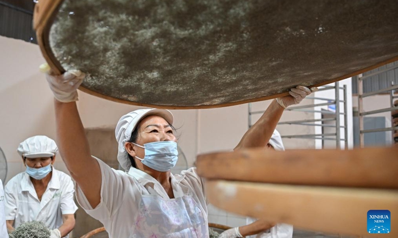 Workers prepare to dry vine tea at a workshop in Laifeng County of Enshi Tujia and Miao Autonomous Prefecture, central China's Hubei Province, Aug. 1, 2025. Laifeng County has leveraged comprehensive industrial chain development to optimize the business ecosystem for vine tea cultivation. The county has expanded its vine tea plantations to 102,000 mu (about 6,800 hectares), generating an annual output value of 2.253 billion yuan (about 321.4 million U.S. dollars). The industry has lifted household incomes for over 20,000 rural families. Photo: Xinhua