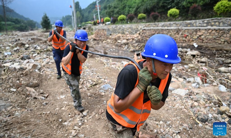 Staff members from the State Grid Corporation of China carry a wire to repair power supply facilities in Nantai Village in Liudaohe Town, Xinglong County of north China's Hebei Province, Aug. 2, 2025. Affected by heavy rainfall, some roads and houses were damaged in several villages in Liudaohe Town. In recent days, local authorities have organized efforts to carry out relief operations to restore roads, power supply and communication facilities, along with environmental disinfection measures. Photo: Xinhua