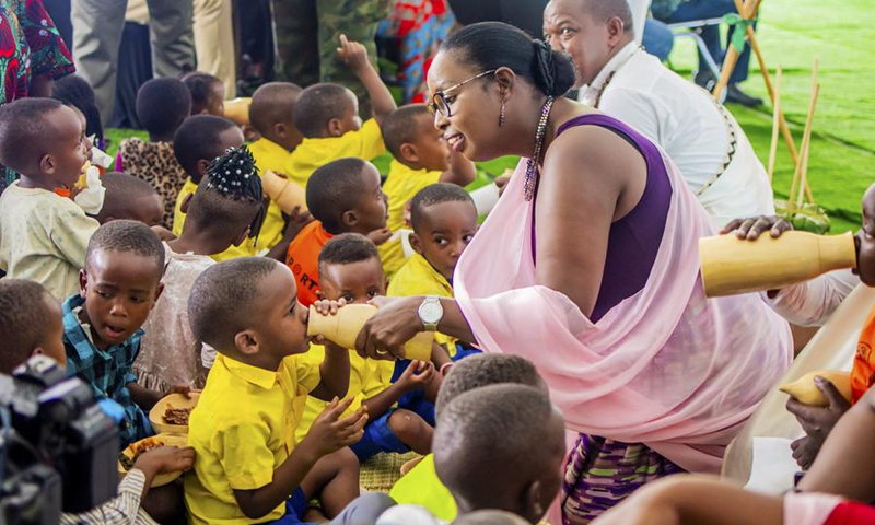 Martine Urujeni, vice mayor of the city of Kigali in charge of social and economic affairs, serves milk to a child during a national harvest day celebration in Kicukiro District, Rwanda, Aug. 1, 2025. Photo: Xinhua