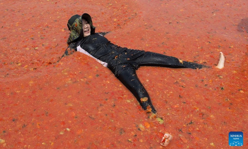 A woman lies in a tomato pool during Hwacheon Tomato Festival in Hwacheon-gun, South Korea, Aug. 2, 2025. Photo: Xinhua