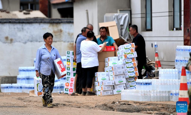 Villagers receive supplies in Nantai Village in Liudaohe Town, Xinglong County of north China's Hebei Province, Aug. 2, 2025. Affected by heavy rainfall, some roads and houses were damaged in several villages in Liudaohe Town. In recent days, local authorities have organized efforts to carry out relief operations to restore roads, power supply and communication facilities, along with environmental disinfection measures. Photo: Xinhua