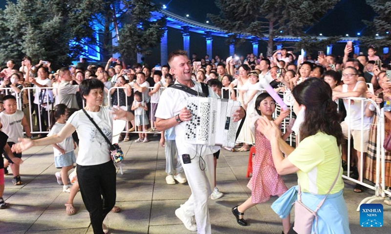 Tourists interact with an accordionist from Russia at a square in Harbin, northeast China's Heilongjiang Province, on July 22, 2025.
Attracted by the coolness in summer, many tourists come to Harbin for vacation.
Taking advantage of its historical heritage, Harbin in recent years has accelerated the transformation of historical and cultural blocks and the utilization of old buildings, which has promoted the prosperity of the city's tourism industry. Photo: Xinhua