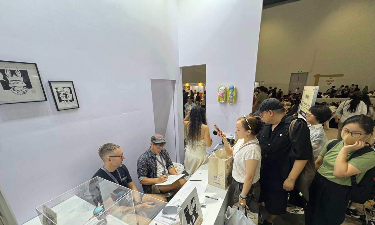 German pop toy designer Mark Landwehr and his team create a hand-drawn illustration for a Chinese buyer at the pop toy show in Beijing on August 2, 2025. Photo: Chen Qingrui/GT