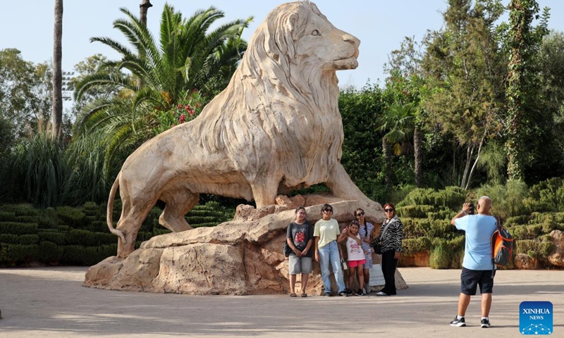 People pose for photos with a statue of Atlas lion in Rabat, Morocco, on Aug. 2, 2025. Photo: Xinhua