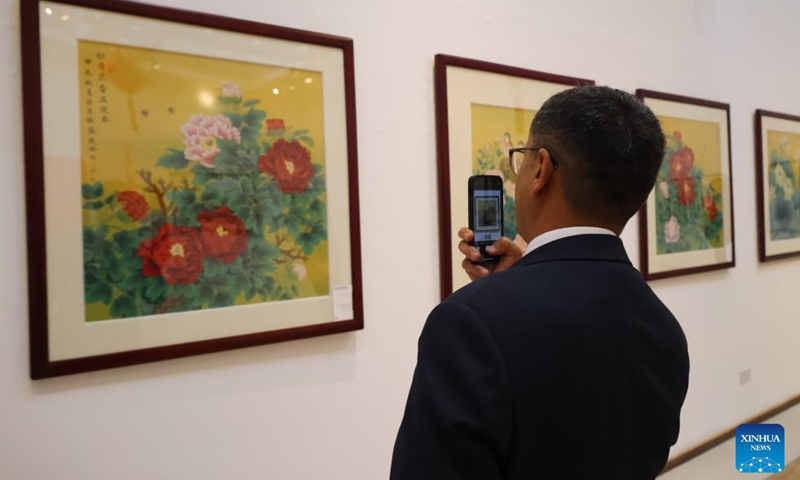 A visitor takes photos at a Chinese fine brushwork painting exhibition in Manama, Bahrain, on Aug. 3, 2025. A Chinese fine brushwork painting exhibition opened on Sunday at the Bahrain Art Centre in Manama, Bahrain, showcasing nearly 50 flower-and-bird artworks by Chinese artist Su Xiaofeng.(Xinhua/Luo Chen)