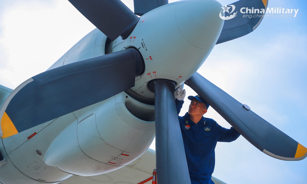 A maintenance technician assigned to an aviation unit under the Chinese PLA Navy inspects the turboprop engine  of an aircraft during a round-the-clock flight training exercise held recently. (eng.chinamil.com.cn/Photo by Xing Yun)
