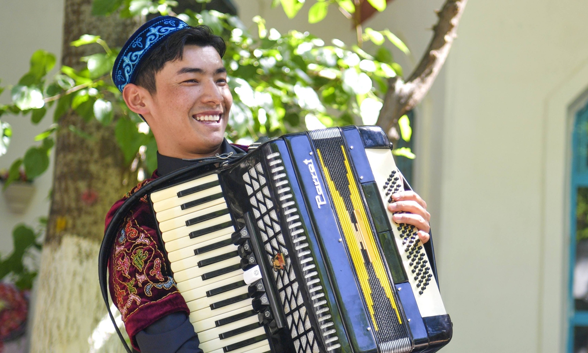 A young man plays an accordion in Yining, Ili Kazak Autonomous Prefecture. Photo: IC