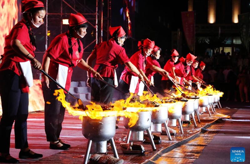 Cooks perform cooking Chaobola, a street food listed as municipal-level intangible cultural heritage, at a food festival in Zhangye, northwest China's Gansu Province, Aug. 2, 2025. Photo: Xinhua