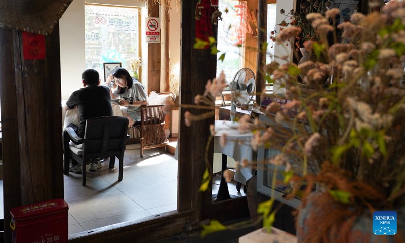 Tourists take a rest at a cafe in Nanping Village, Taiping Town, Nanchang City of east China's Jiangxi Province, Aug. 1, 2025.