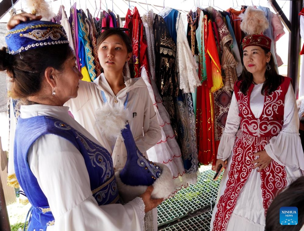 Tourists try traditional costumes at Narat scenic area in Xinyuan County of Ili Kazak Autonomous Prefecture, northwest China's Xinjiang Uygur Autonomous Region, Aug. 3, 2025. Ili Kazak Autonomous Prefecture has ushered in its peak tourism period. The region's unique natural landscapes and cultural sites have attracted a large number of visitors. It received 54.93 million domestic tourists in the first seven months of this year, a year-on-year increase of 10.31 percent. (Xinhua/Liu Lianfen)