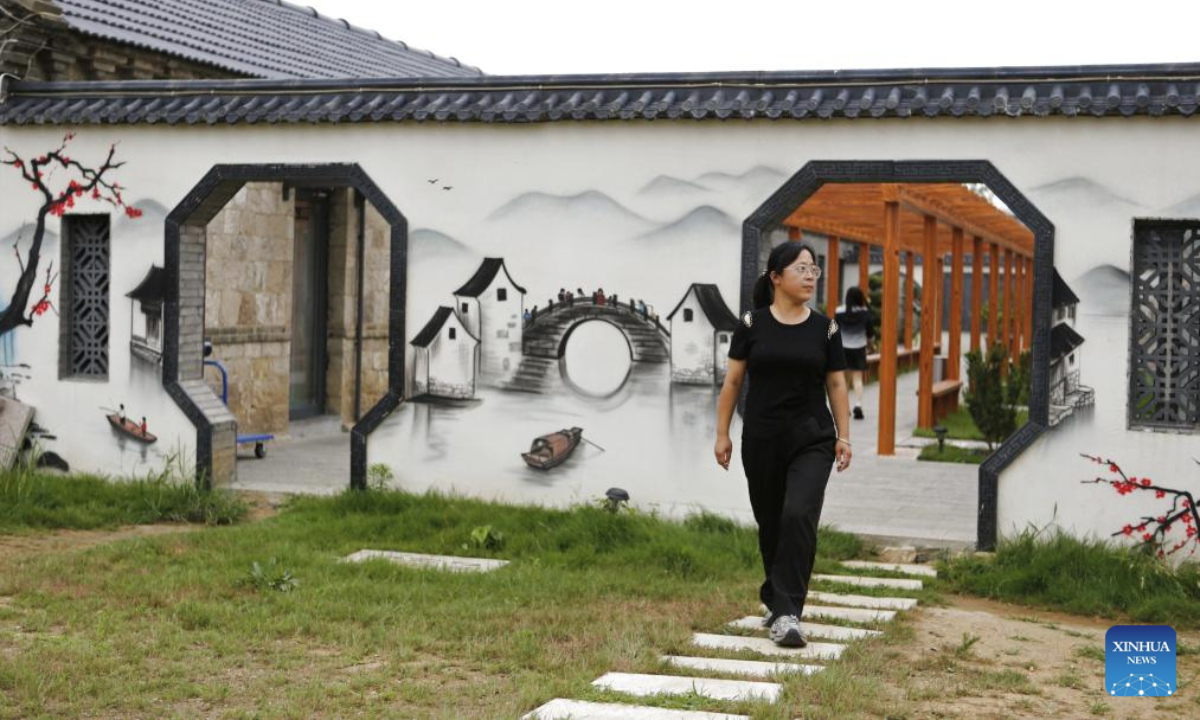 A tourist visits a resort which was once a mine pit in Laixi City, east China's Shandong Province, Aug. 5, 2025. In recent years, local authorities have transformed a closed mine pit into a resort, a move to promote local ecological environment. (Xinhua/Ding Hongfa)