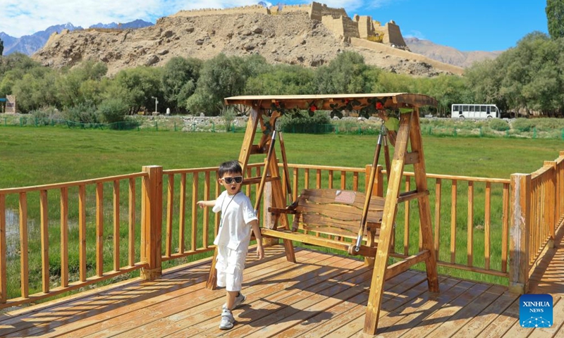 A boy has fun at a national wetland park in Tajik Autonomous County of Taxkorgan, northwest China's Xinjiang Uygur Autonomous Region, Aug. 2, 2025. Tajik Autonomous County of Taxkorgan has entered the peak travel season as more tourists come here to experience the culture and enjoy the scenery on the plateau. (Xinhua/Wang Fei)