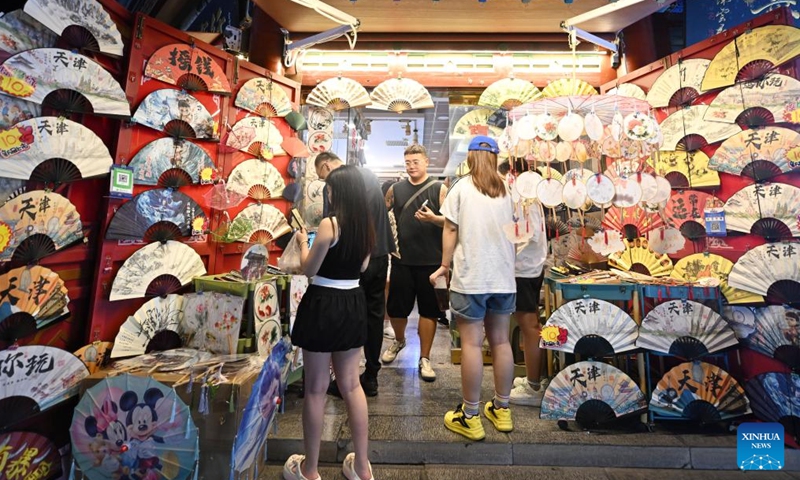 Tourists visit an ancient cultural street in north China's Tianjin Municipality, Aug. 3, 2025. Local shop-owners have extended operating hours and organized live performances to attract visitors, boosting the summer economy. (Xinhua/Zhao Zishuo)