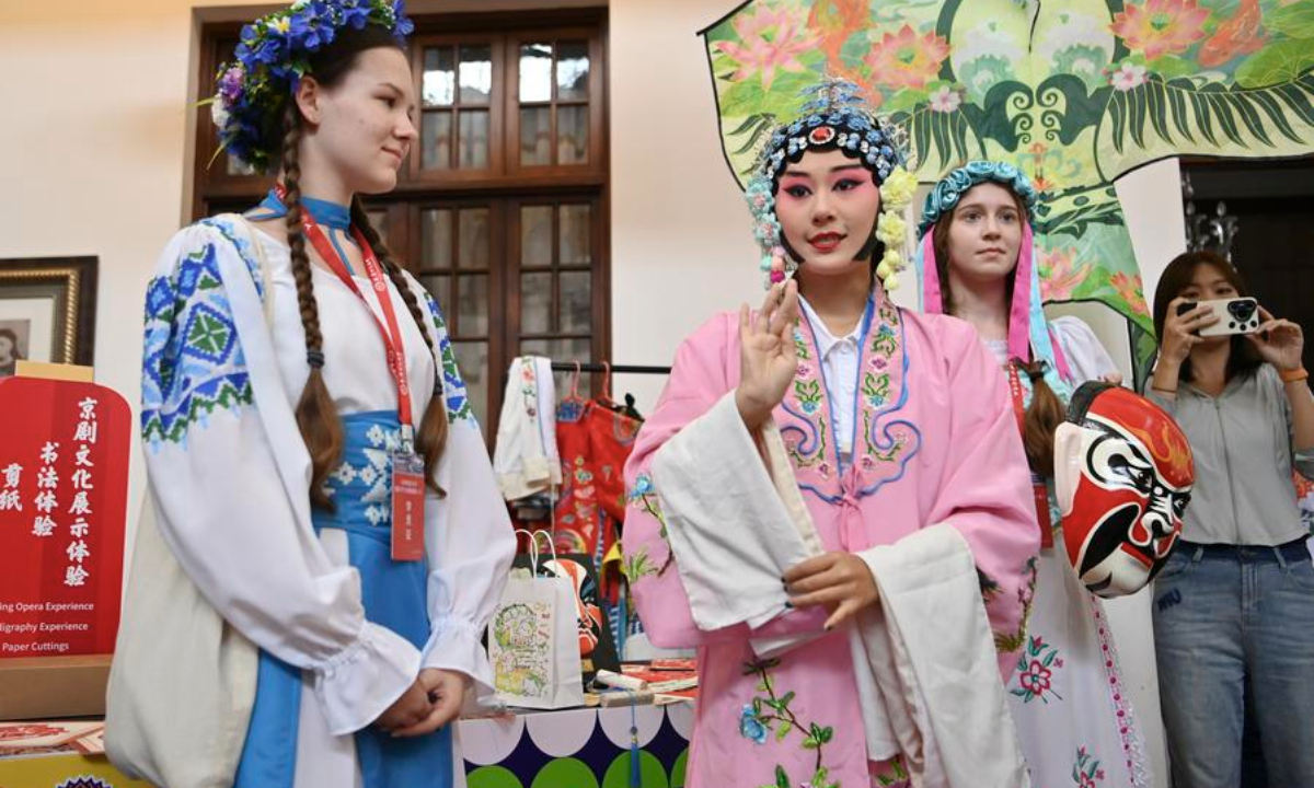 Young students from the Shanghai Cooperation Organization (SCO) countries try on Beijing Opera costumes during the Kaleidoscope Cultural Bazaar in north China's Tianjin, Aug. 6, 2025. (Xinhua/Li Ran)