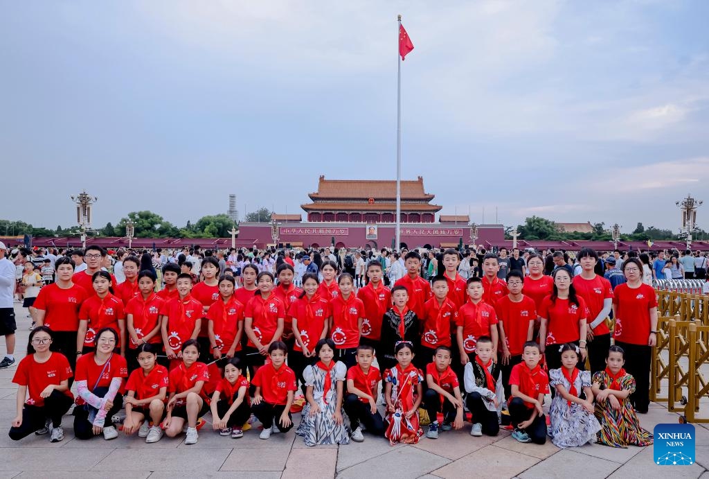 Patimanhan Parihat (6th R, front) takes a group photo with friends of the summer camp after watching a national flag-raising ceremony at Tian'anmen Square in Beijing, capital of China, July 31, 2025.