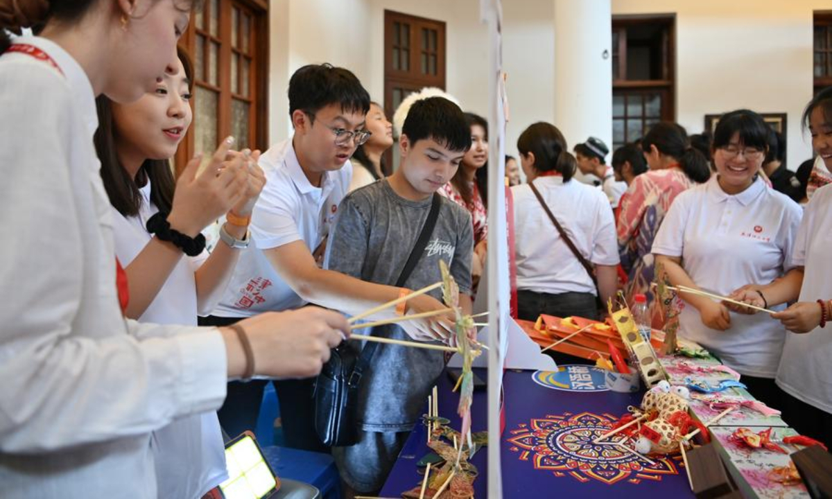 Young students from the Shanghai Cooperation Organization (SCO) countries try shadow puppet show during the Kaleidoscope Cultural Bazaar in north China's Tianjin, Aug. 6, 2025. (Xinhua/Li Ran)
