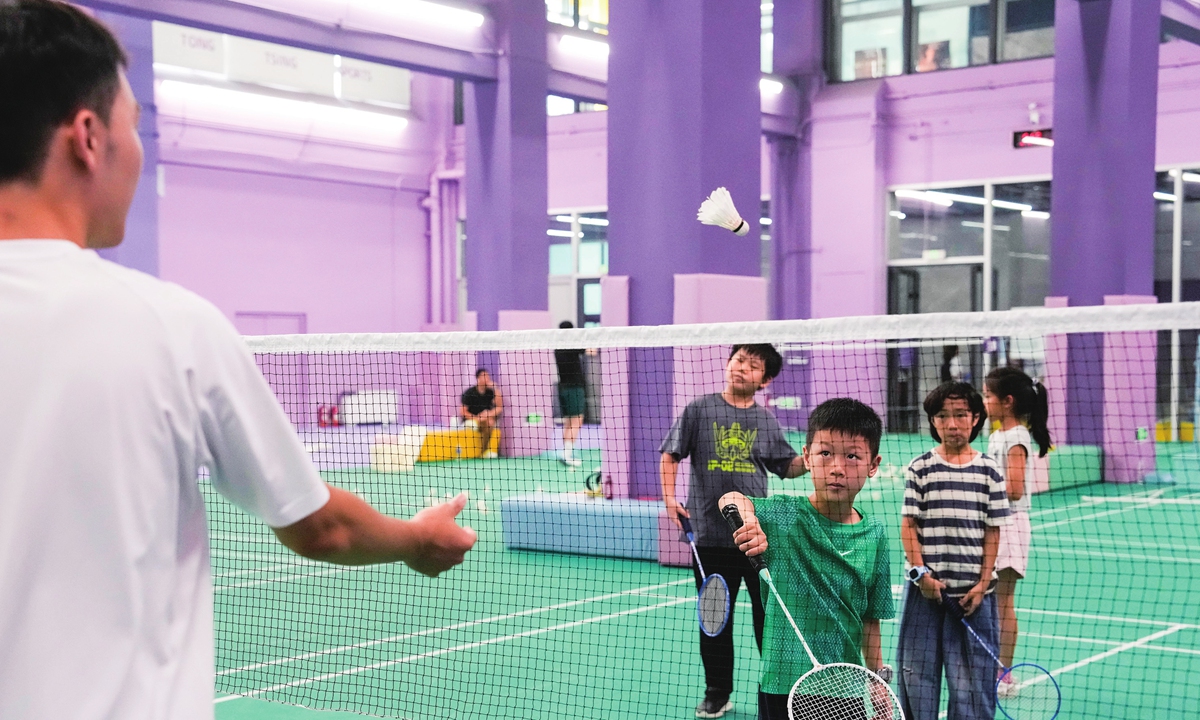 Children play badminton in a gym in Beijing on July 22, 2025. Photos on this page: VCG