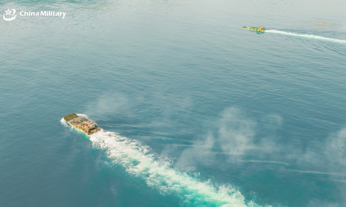Two amphibious assault vehicles attached to an amphibious armored vehicle detachment of a brigade under the PLA Army swim towards shooting positions during a maritime shooting training exercise on July 13, 2025. (eng.chinamil.com.cn/Photo by Zeng Bingyang)