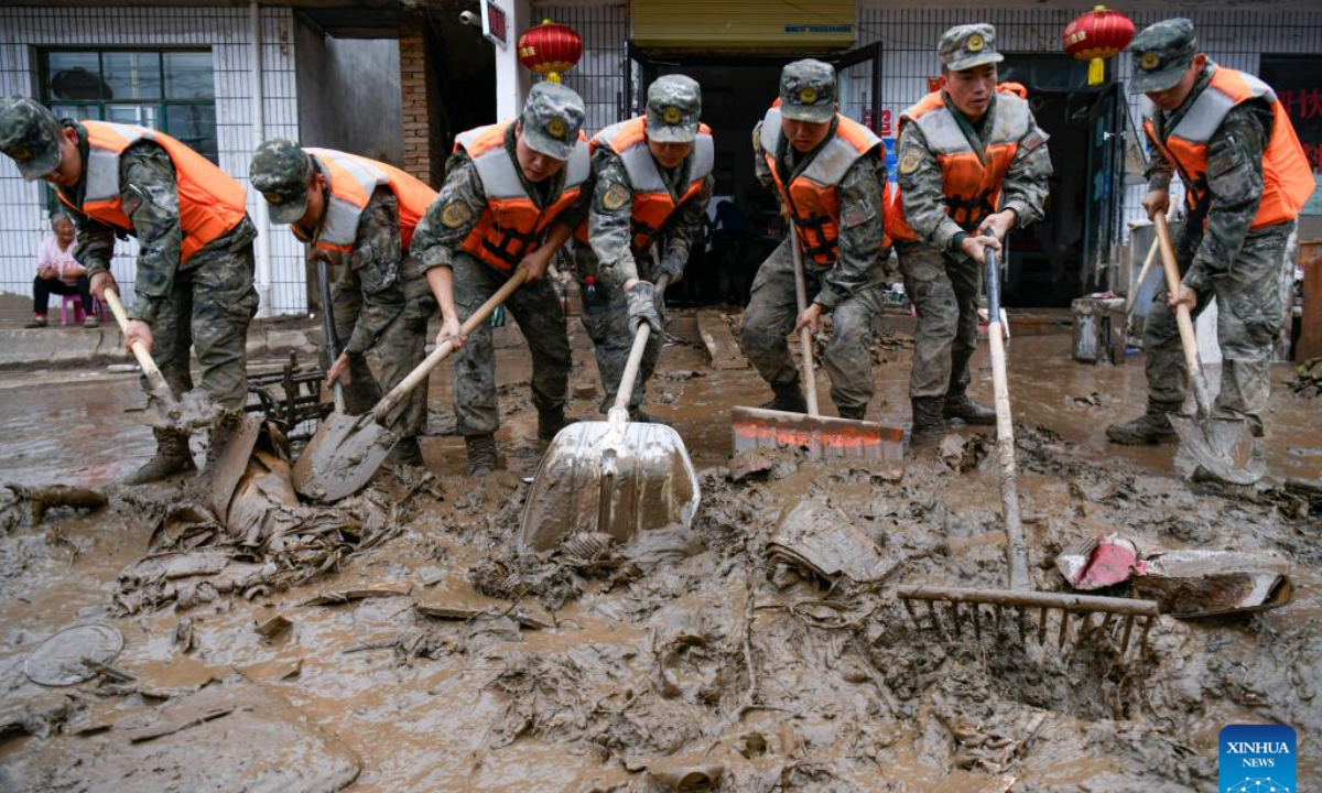 Rescuers clear debris outside the houses of disaster-affected villagers in Chengguan Town of Yuzhong County, Lanzhou City, northwest China's Gansu Province, Aug. 9, 2025. Rescue efforts are underway after continuous heavy rainfall triggered mountain torrents in Yuzhong County. (Photo by Hou Chonghui/Xinhua)