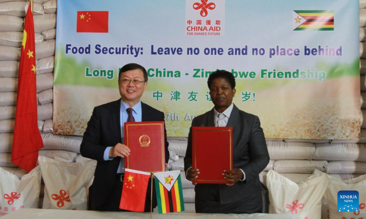 Chinese Ambassador to Zimbabwe Zhou Ding (L) and Zimbabwean Deputy Minister of Public Service, Labor and Social Welfare Mercy Dinha attend the handover ceremony of food assistance in Harare, Zimbabwe, Aug. 7, 2025.(Xinhua/Tafara Mugwara)