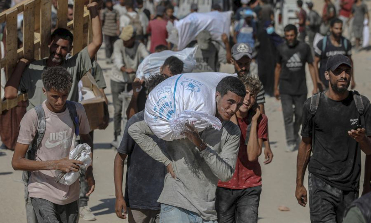 Palestinians fetch humanitarian aid in Beit Lahia, northern Gaza Strip, on Aug. 5, 2025. (Photo by Rizek Abdeljawad/Xinhua)