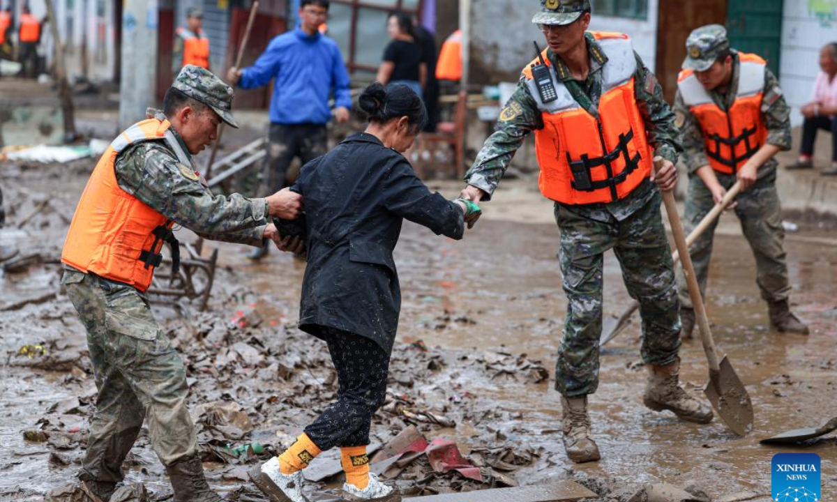 Rescuers help evacuate a disaster-affected villager in Chengguan Town of Yuzhong County, Lanzhou City, northwest China's Gansu Province, Aug. 9, 2025. Rescue efforts are underway after continuous heavy rainfall triggered mountain torrents in Yuzhong County. (Photo by Hou Chonghui/Xinhua)