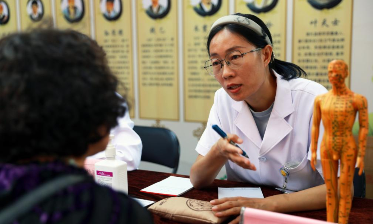 Song Wanling (R), a doctor of a maternal and child health care hospital in Baiyin, offers free consultation services at the Traditional Chinese Medicine (TCM) Night Market in Baiyin City, northwest China's Gansu Province, July 15, 2025. (Xinhua/Guo Gang)