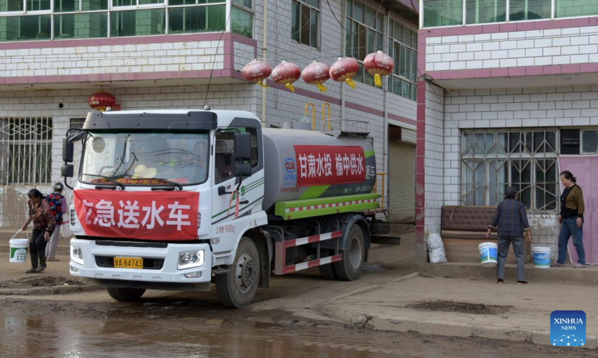 Workers of the water resources department deliver drinking water to villagers in Xinglongshan Village, Yuzhong County of northwest China's Gansu Province, Aug. 11, 2025. Roads damaged by mountain torrents in Yuzhong County reopened on Sunday and power supply has been restored following the disaster that left 13 dead and 30 missing. (Xinhua/Fan Peishen)