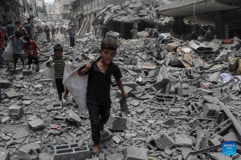 Children walk on rubbles after an Israeli airstrike in the Al-Rimal area, west of Gaza City, on Aug. 8, 2025. (Photo by Rizek Abdeljawad/Xinhua)