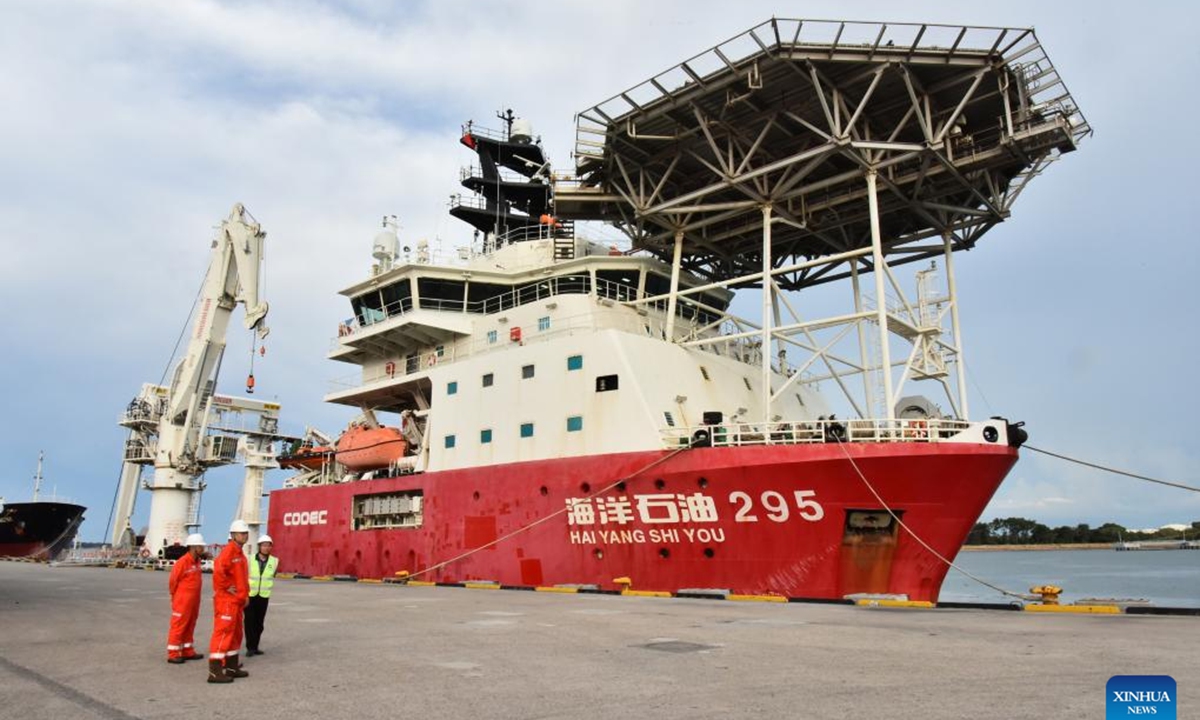 Crew members of China's HYSY 295 trenching vessel are pictured near the vessel at Muara Port in Brunei, Aug. 8, 2025. Designed and built in China, the HYSY 295 trenching vessel is launching its first engineering project mission in Brunei. (Xinhua/Li Meng)