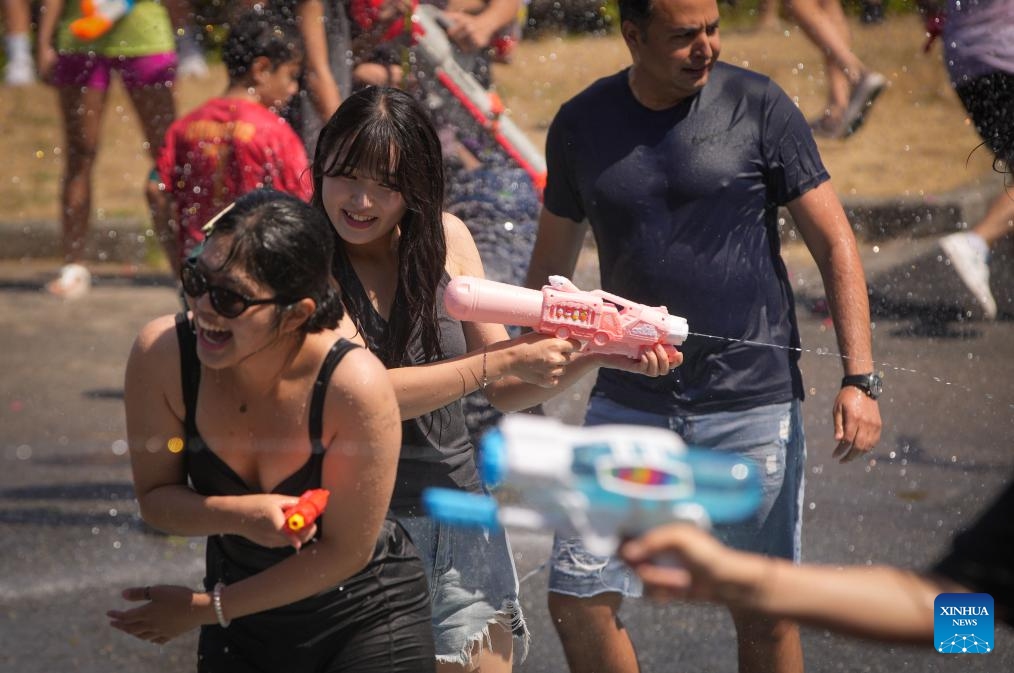 People tease each other with water guns during the flash mob-style water fight at Stanley Park in Vancouver, British Columbia, Canada, on Aug. 9, 2025. (Photo by Liang Sen/Xinhua)