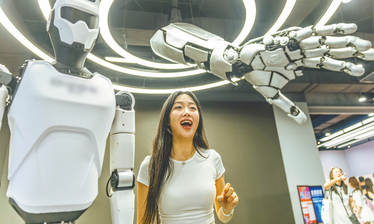 A visitor is interacting with a humanoid robot at the 2025 World Robot Conference on August 9, 2025 in Beijing. Photo: Li Hao/GT