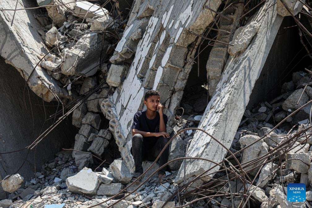 A boy sits among rubbles after an Israeli airstrike in the Al-Rimal area, west of Gaza City, on Aug. 8, 2025. (Photo by Rizek Abdeljawad/Xinhua)