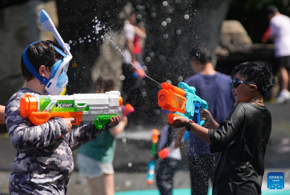Children tease each other with water guns during the flash mob-style water fight at Stanley Park in Vancouver, British Columbia, Canada, on Aug. 9, 2025. (Photo by Liang Sen/Xinhua)