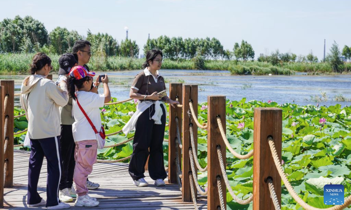 People visit the Manas national wetland park in Manas County, Changji Hui Autonomous Prefecture, northwest China's Xinjiang Uygur Autonomous Region, Aug. 10, 2025. In Xinjiang, new wetlands such as the Manas national wetland park and the Lalikun wetland nature reserve have emerged near the border of Gurbantunggut Desert and Taklimakan Desert, acting as important ecological shelters for migrant birds and safeguarding the biodiversity and oases in the region. (Xinhua/Zhou Jiayi)