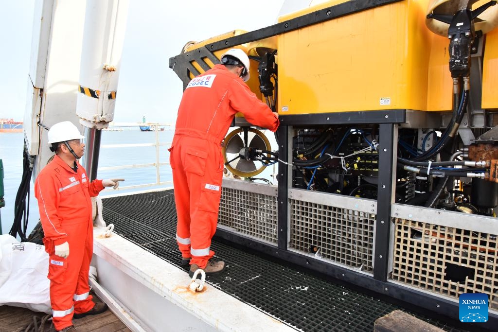 Qiao Baoxin (L), captain of China's HYSY 295 trenching vessel, and a crew member inspect the underwater work robot on the vessel at Muara Port in Brunei, Aug. 8, 2025. Designed and built in China, the HYSY 295 trenching vessel is launching its first engineering project mission in Brunei. (Xinhua/Li Meng)